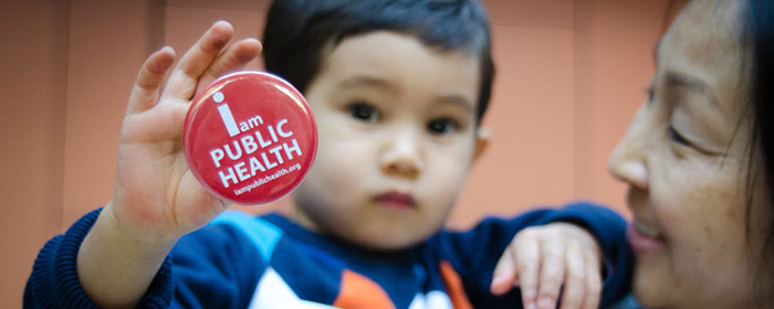 kid holding i am public health pin